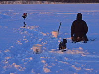 image of ice fishing holes augered in a line